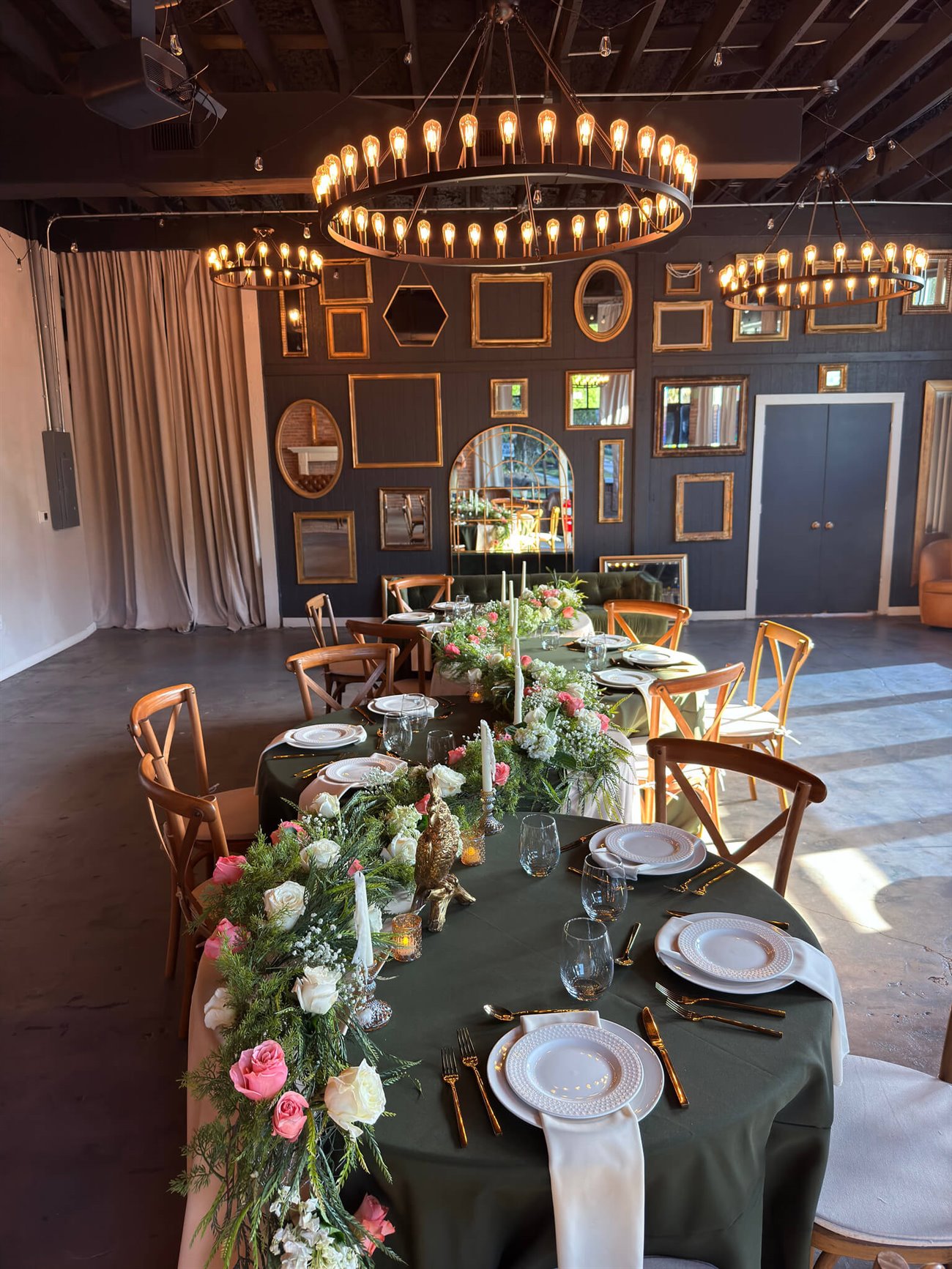 The event floor at The Cove set for dinner beneath ring chandeliers and a wall of gilt mirrors